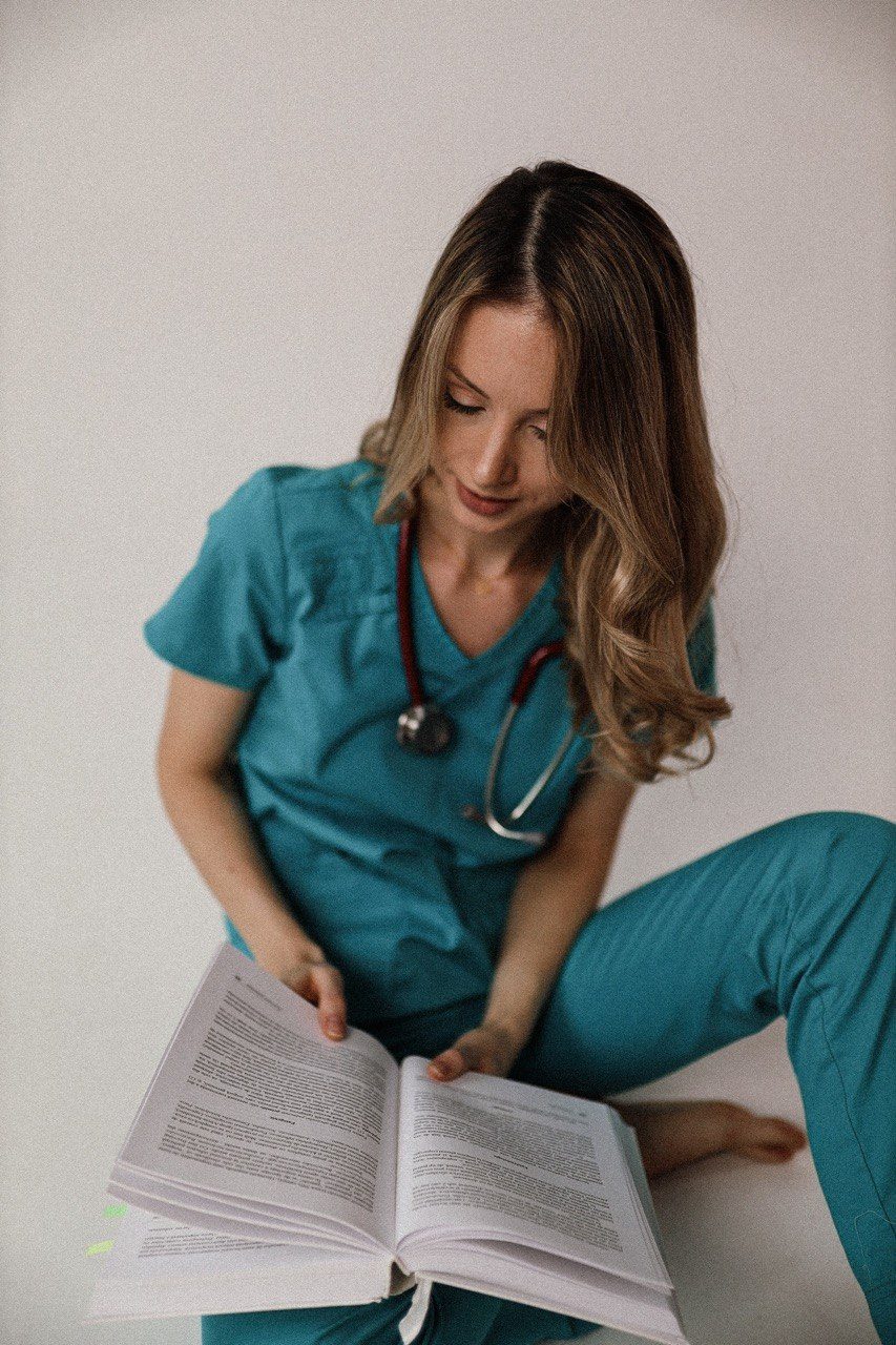 Dr. Elena Pușca, citind un tratat de medicină, cu stetoscopul la gât