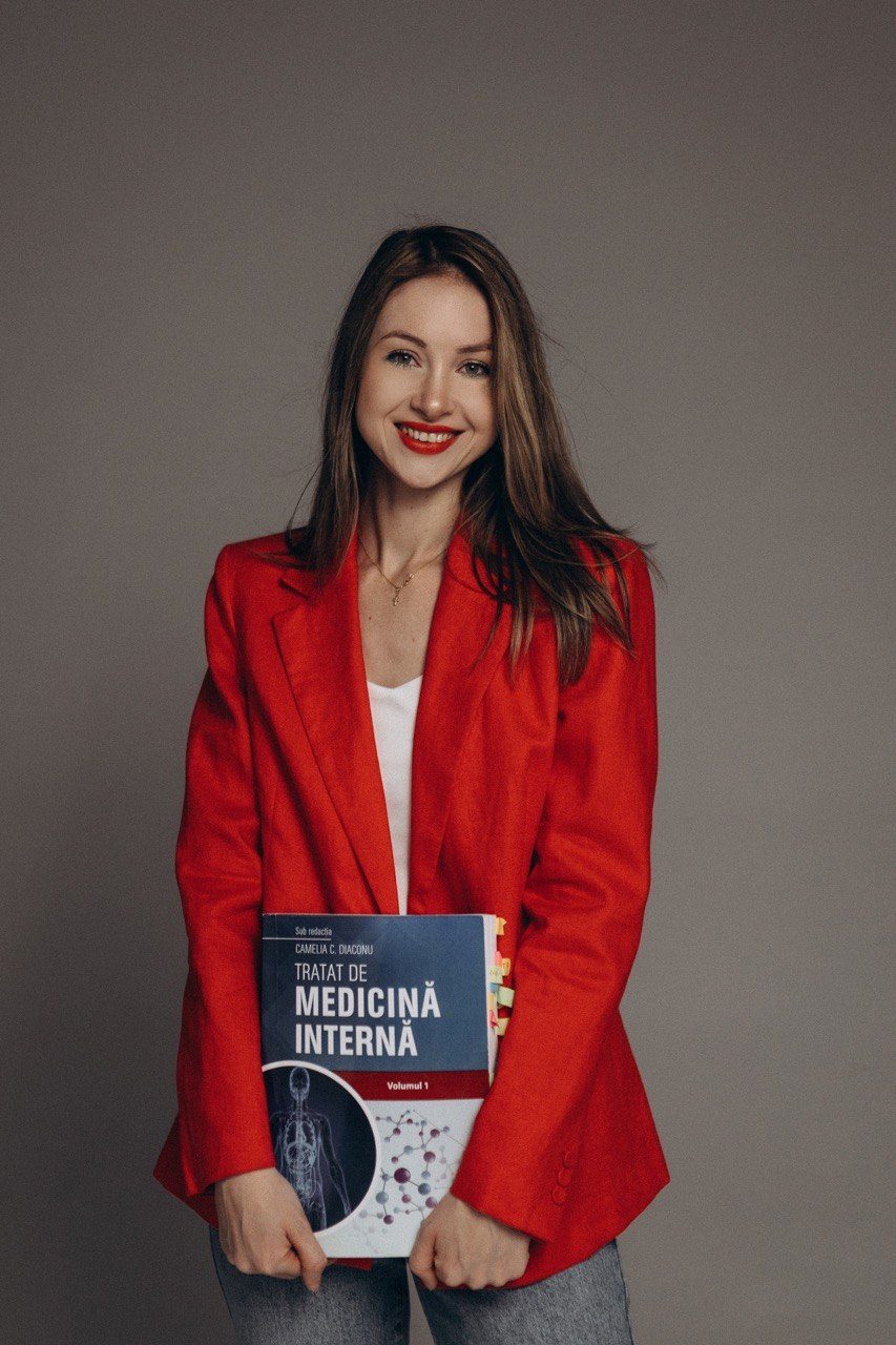 Dr. Elena Pușca, în sacou roșu, cu Tratatul de Medicină Internă în brațe